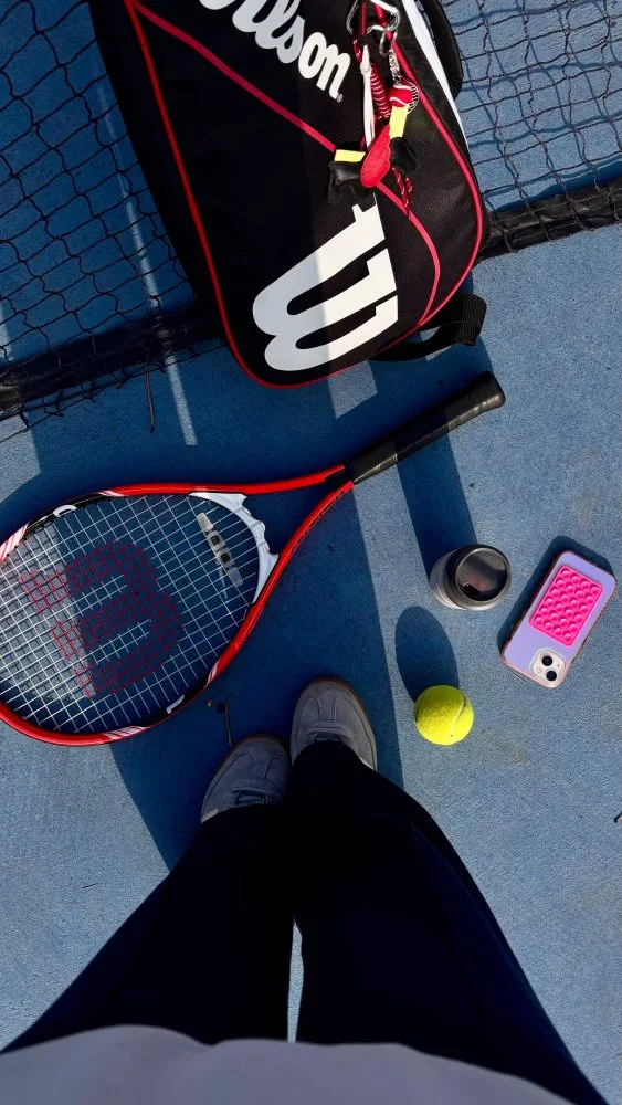 Tennis racket, balls and phone with the REQUR app