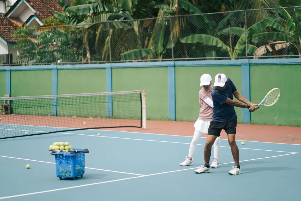 Tennis coach giving a lesson on an outdoor court