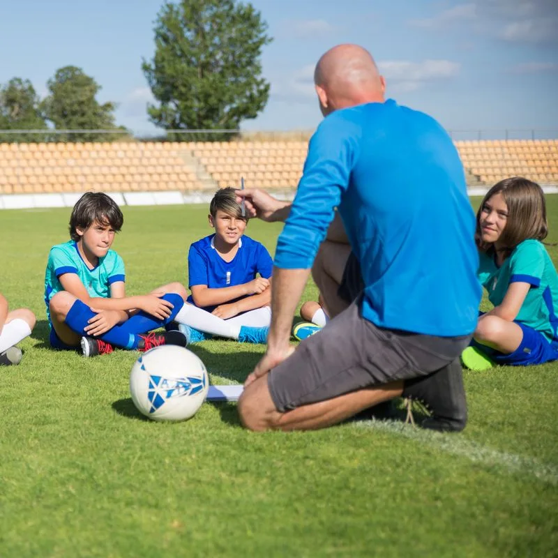 Football coach giving a training session on the pitch